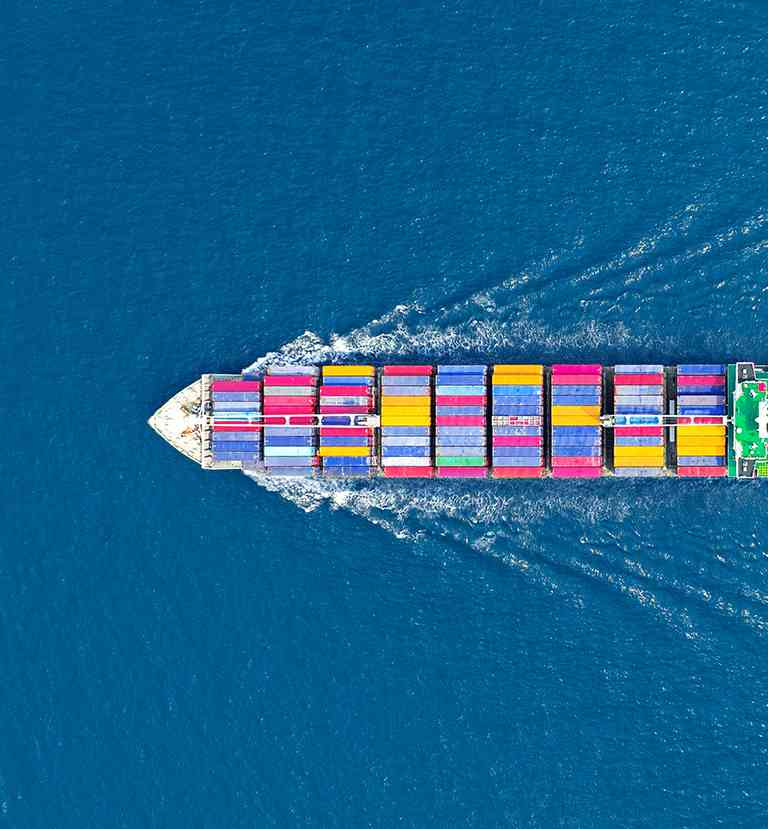 A cargo boat from above sails through the sea